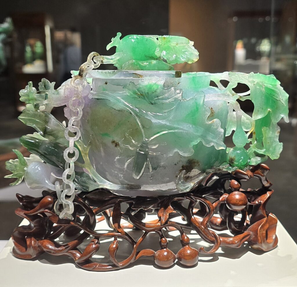 Jadite purfume bottle featuring splashes of green and lavender in the shape of a cucumber.